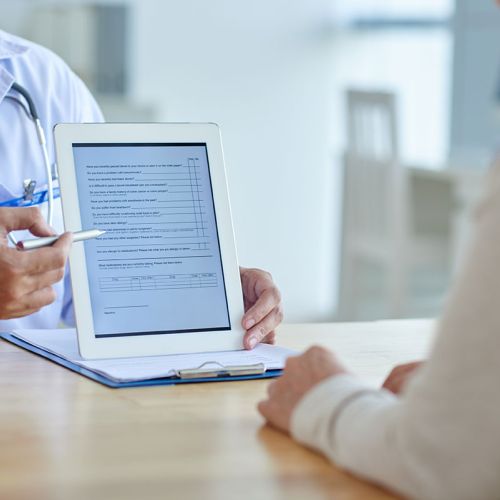 doctor showing a patient a iPad with information
