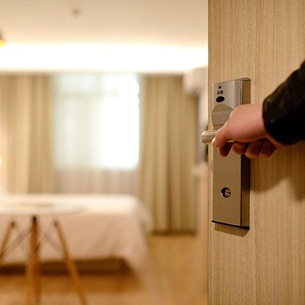 A person opening a hotel room door, showcasing the welcoming atmosphere of hotel accommodation design.