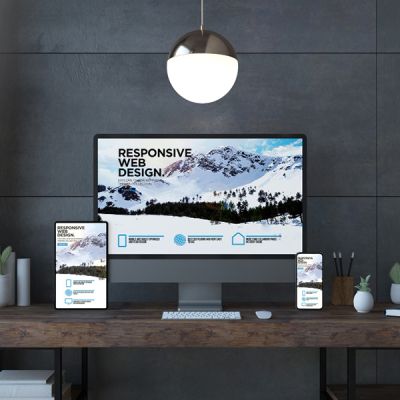 A desk equipped with a computer, phone, and tablet, highlighting the concept of responsive website design.