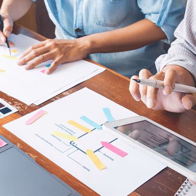 Team members engaged in a UX web design project, discussing ideas and working together at a conference table.