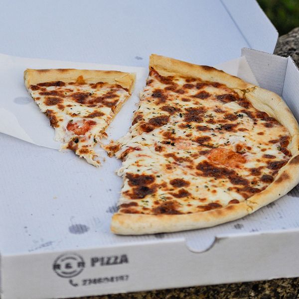 A pizza placed in a box, illustrating website design concepts for takeaway food establishments.