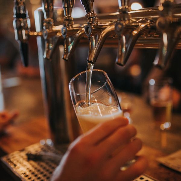 A bartender pouring beer into a glass, illustrating the vibrant experience of a pub for a bar website design.