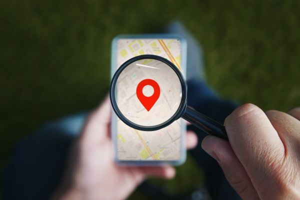 phone with map and man holding magnifying glass
